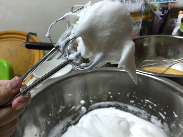 蛋白打出泡泡後，砂糖分三次加入，檸檬汁於第三次同步加入，打成尾端彎曲的蛋白霜（濕性發泡）。