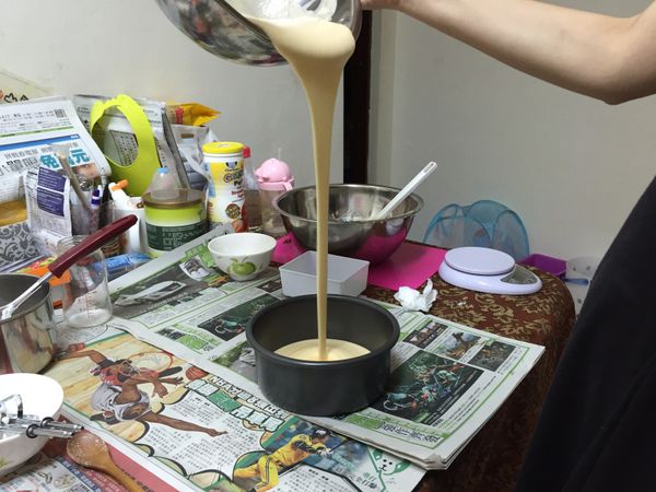攪拌均勻後。將蛋糕麵糊倒入模具，拉高點倒入可將氣泡擠壓出來。