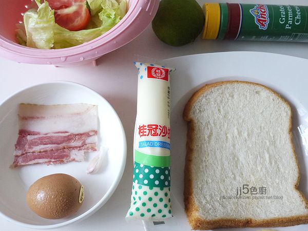 材料如用一份培根蛋三明治。生菜葉洗淨撕小片。番茄洗淨切塊。培根切丁。