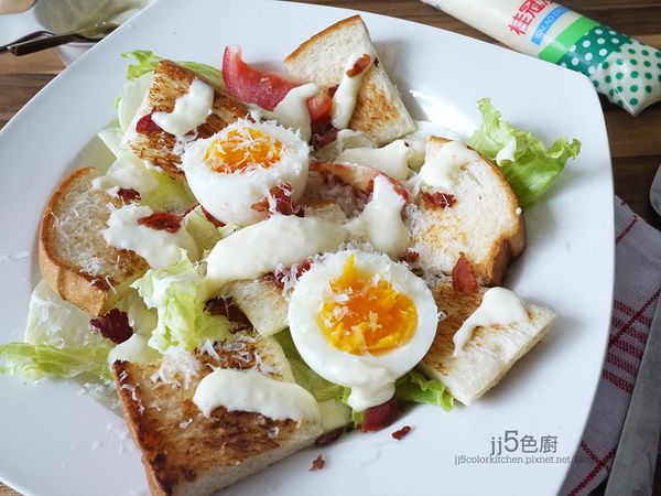 取一深碗，先鋪上生菜葉片，放上番茄塊、土司塊、糖心蛋、培根碎，再灑上起司粉（或現磨乾酪），最後淋上凱撒沙拉醬便ok.