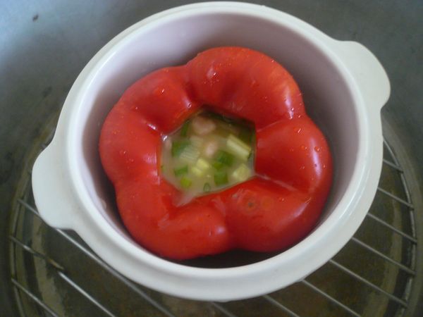 將處理好的紅椒放入傳統電鍋內，外杯加一杯水，蓋上鍋蓋，按上開關進行蒸煮動作。