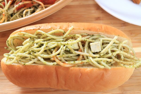 將義大利麵條與乳酪丁放到熱狗麵包內。