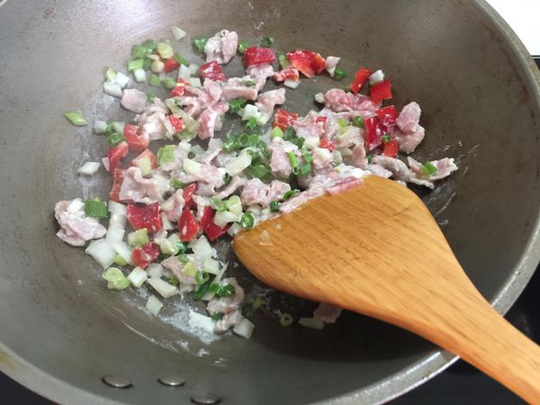 紅椒、烤肉片切小塊放入鍋中炒至豬肉變白、炒熟，再加入蔥花炒勻