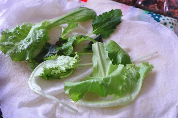 將潤餅捲皮攤開，放入適量的綜合生菜(小黃瓜、蔥絲、香菜皆可)