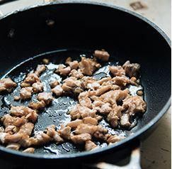 加熱鍋子，用中大火將鮭魚雙面煎上色，然後用炒勺把鮭魚炒碎並煎乾。入醬油和酒調味，炒到醬汁收乾。