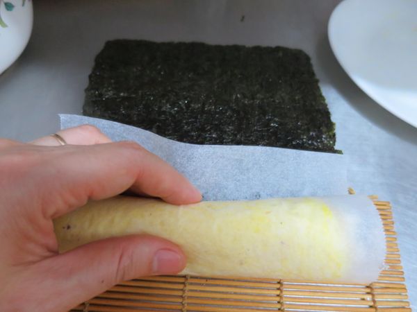 多出的海苔片剪掉，開始捲起來。