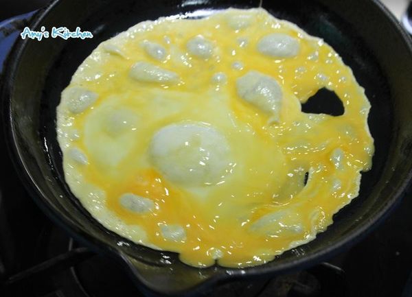 接著將餅皮拿起來先放至一旁，抹些油後將打散的蛋液倒入進去