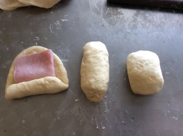 撖成比火腿片略大的麵片，放上火腿片，捲成卷，兩端揑緊。再將兩頭接合起來，接口處朝下。