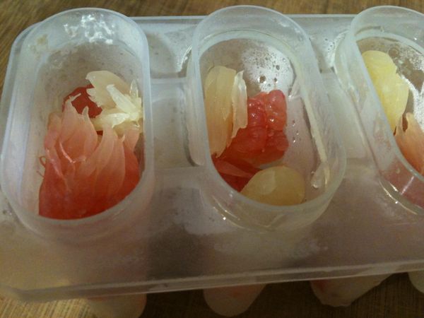 拿出製冰盒，用小湯匙挖入優格，再用筷子夾入柚子肉。依「一層優格、一層柚子肉」的方法重覆數次。