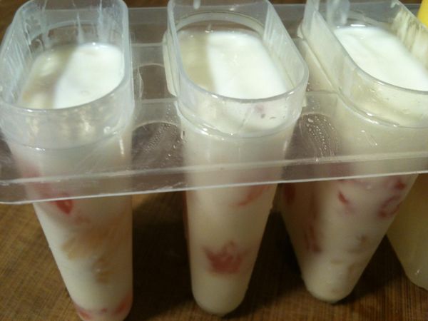 將製冰盒放在桌上敲一敲（目的是使優格填滿空隙）。