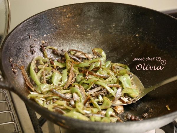 中大火熱鍋及一大匙油，豆豉和小魚乾下鍋炒香（約一分鐘），青椒下鍋拌炒一下，加米酒和醬油炒至青椒熟，試吃調味。