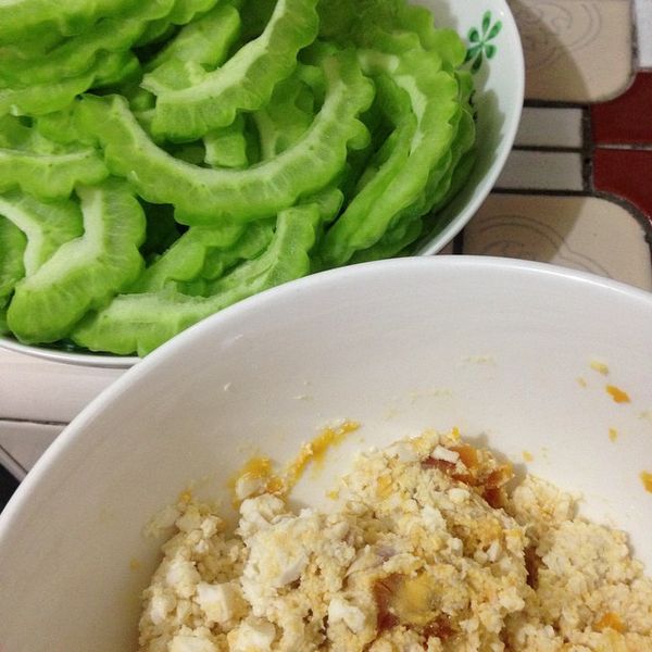 先將苦瓜洗淨並去籽去囊...再切薄片，鹹蛋敲殼後拿湯匙挖出放入碗中...再用湯匙弄碎蛋白蛋黃，兩項食材先備用