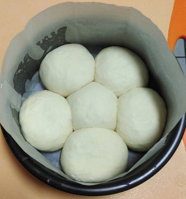 6吋圓模,底及四週(刷少許油)鋪烘培紙,將包好餡如圖置入圓模中, 入烤箱(放1碗熱水)二發45分(約6~7分滿)