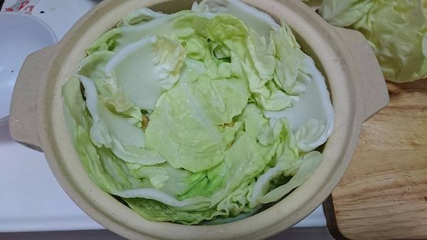 重要的部份來了~切好均等的白色菜梗開始排排站好，如圖這樣一片片由砂鍋邊開始向內排