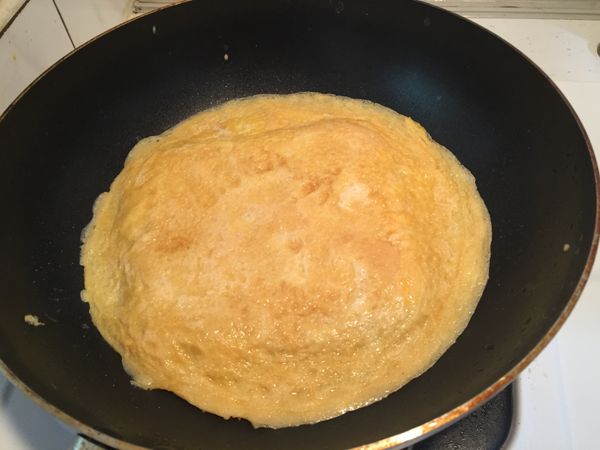 1. 後再將蛋皮倒蓋於平底鍋（吐司面朝下）將吐司面稍微煎一下，至蛋液不會流動。
2. 再將吐司從鍋子中倒蓋回盤中，讓吐司面朝上。