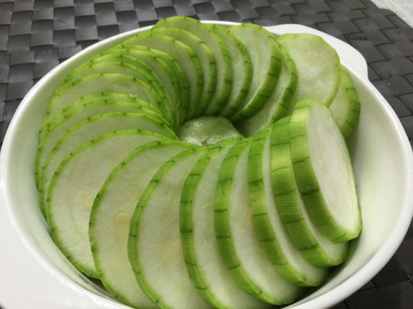 將絲瓜切成厚約 0.5公分的圓片， 排入有些高度的淺盤內，能盛裝湯汁。