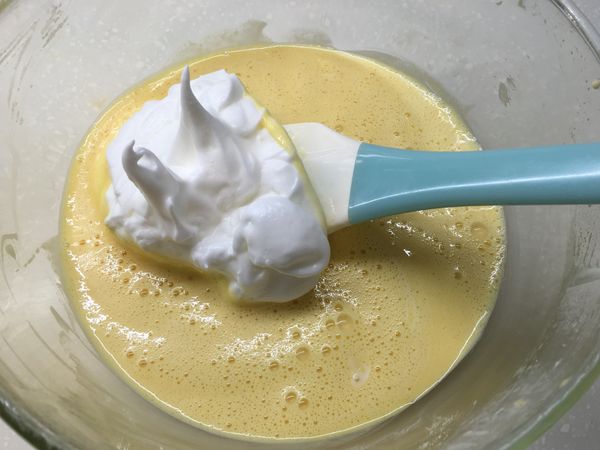 將打發好的[蛋白霜]，分次加入[蛋黃液]中攪拌均勻。