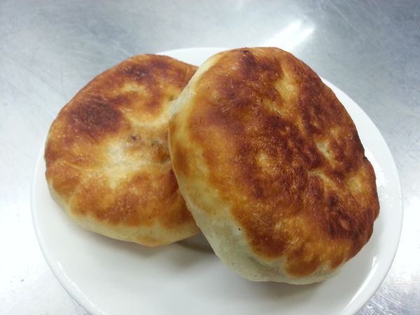 平底鍋加入適量的油，以小火加熱，放入包好的餡餅並壓成圓餅狀，煎至兩面金黃色即完成（煎好前內餡會有少量的肉汁溢出，小心油會小小的噴濺，勿被噴到）