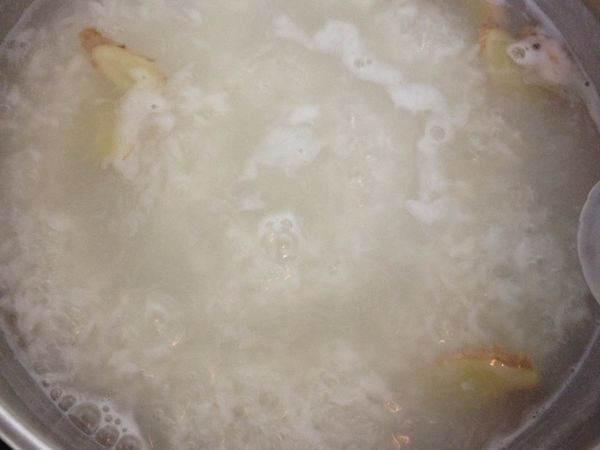 取一鍋水（10杯水）滾後入白米 滾至米心微透 放入薑片