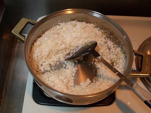 步驟3:加一些橄欖油，把生米放進鍋裡，拌炒到到稍稍呈現透明