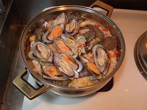 步驟5:再把墨魚、蝦、貝類，加上剛剛放到一邊的雞肉下鍋，放一些白酒及番紅花一起炒提味