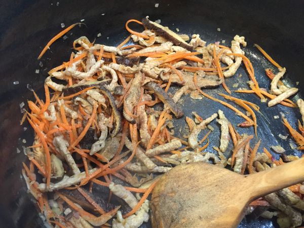 依序加入香菇絲、櫻花蝦、肉絲、紅蘿蔔絲炒香（每加一樣都必須等炒出香味後，再加下一樣），再加入胡椒粉拌炒。