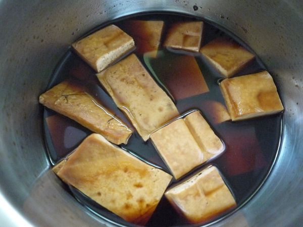 將豆乾放入鍋中，滷汁為剛好蓋過豆乾的高度，電鍋外鍋倒一杯水，開關跳起稍涼切片盛盤，灑上葱花淋上少許香油即可享用。