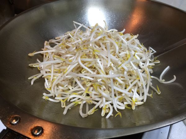 以廚房紙巾將炒鍋擦拭乾淨，加2大匙油爆香蔥白，再加入豆芽菜和半米杯水大火炒