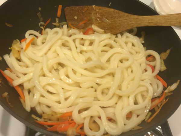 因為烏龍麵我買都是冷凍的所以我會先放滾水裡燙一下讓他分散。再加入跟菜一起炒。然後加入鹽和胡椒。嚐嚐味道然後再做調整。