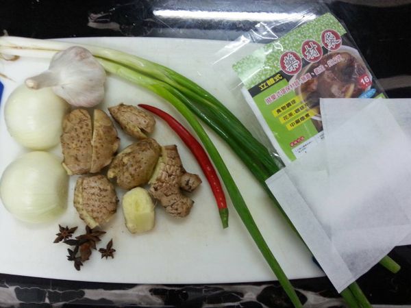 將以下食材放入藥材袋中: 老薑拍碎、青蔥不去鬚、大蒜整顆不去皮、洋蔥切半、八角、辣椒