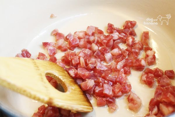 鑄鐵鍋入沙拉油加熱後放進香腸丁煎香,然後把蒜頭也放進來炒香。