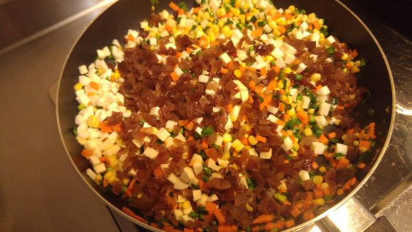 依序放入玉米粒、筊白筍、韭菜(小黃瓜)、木耳，加上兩大匙的水、胡椒粉、鹽巴調味，中小火拌炒，可加上鍋蓋悶一下。