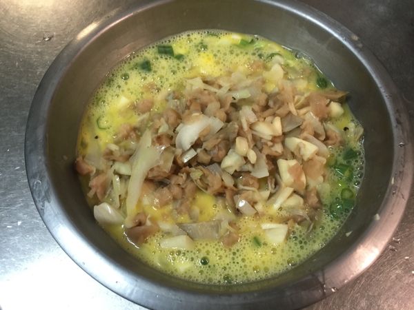 把爆炒後的洋蔥未、秀珍菇段和菜脯放入已事先打好的蛋汁內(蔥花、鹽、柴魚精已先拌勻好)，拌勻備用