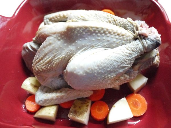 全雞從袋中取出撥掉蒜頭放在蔬菜上,剩餘醬料留著待會要刷在雞肉上。