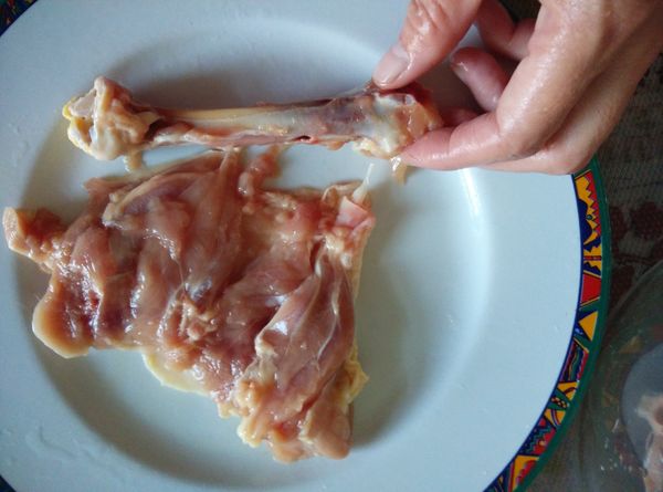 將雞腿劃開一刀，取出中間的腿骨。