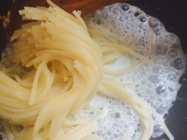 把義大利麵撈起放至平底鍋，喇ㄧ下後（麵會自己分開）加上起士或起士粉，再喇ㄧ下即可放置盤中。