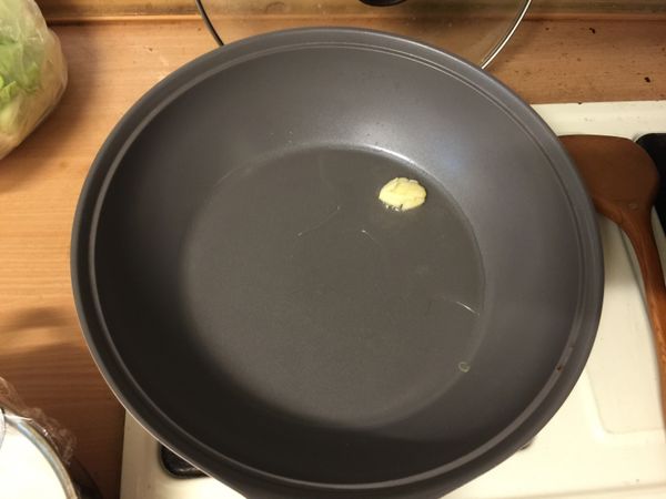 起油鍋，將大蒜拍開並在上面劃幾刀