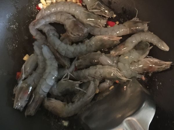 冷凍蝦退冰後剝殼，放入熱鍋內拌炒