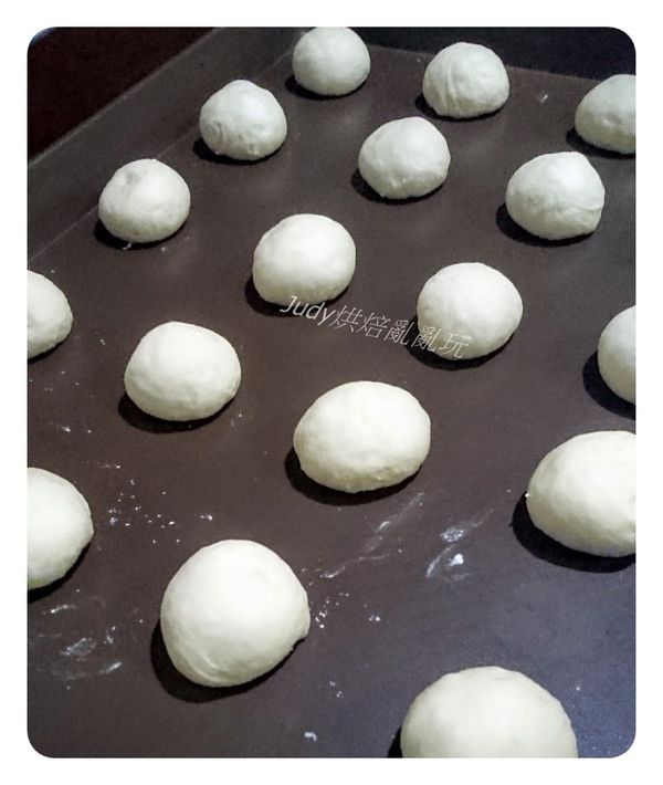 休息好的麵團再次分別滾圓，間隔整齊放入烤盤中噴些水放烤箱中發酵50分鐘