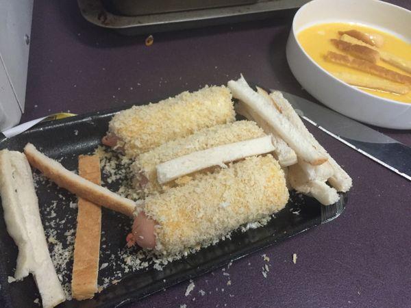 把香腸放進麵包糠裡面滾一下