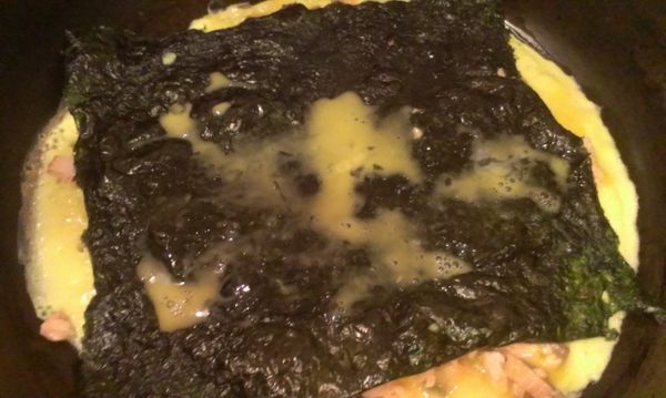 在把剩下蛋汁淋在海苔上，以方便等下好黏起來，再以捲蛋餅方式捲起，稍煎一下即可。