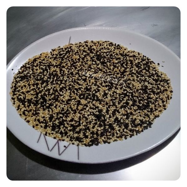 將表面裝飾用的黑、白芝蔴放入一盤子中，混合均勻備用