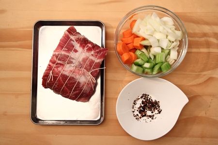 將肉用綿線綁好，胡蘿蔔／洋蔥及西洋芹切大塊，大蒜切片，黑胡椒粒／杜松子／丁香用紙巾包用，以木搥敲碎．