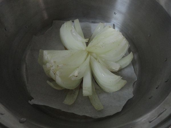 把烘培紙放入大同電鍋內,不用加水.洋蔥頭去頭尾中間去芯(不去也行),從上往下切未斷,共切16刀.   大同智慧型電鍋,按"選擇"->"糕點"->"開始".