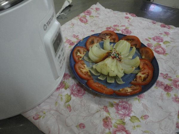 擺上蕃茄片,中間放蕃茄醬和彩色米粒巧克力."洋蔥花"即完成.