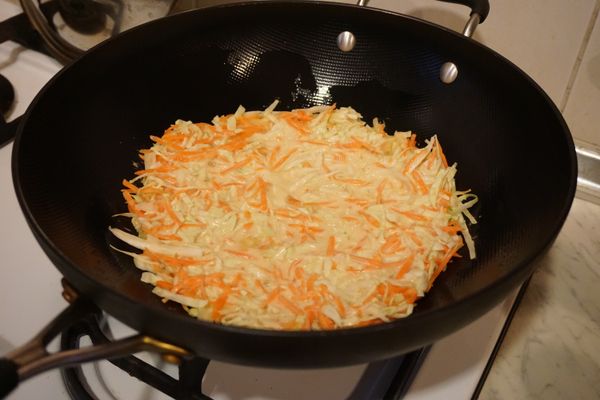 熱油鍋後，倒入所有蔬菜麵糊，使蔬菜糊均勻舖平於鍋內，慢火煎它，再煎另一面。