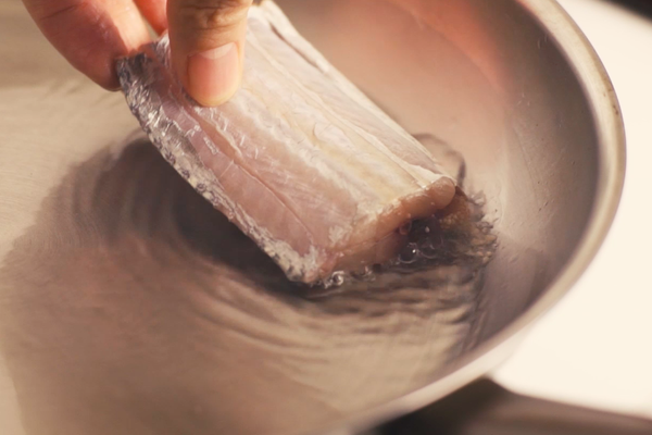 輕輕將每片魚段的其中一「面」放至鍋中。