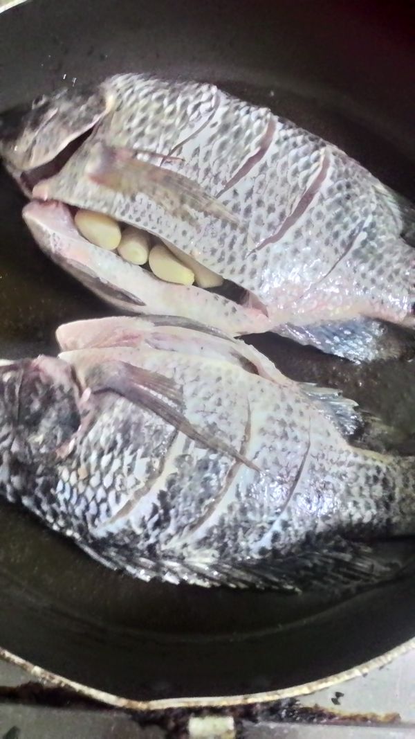 起油鍋，將魚放入煎，因為有多蒜頭就把它塞魚肚肚裡