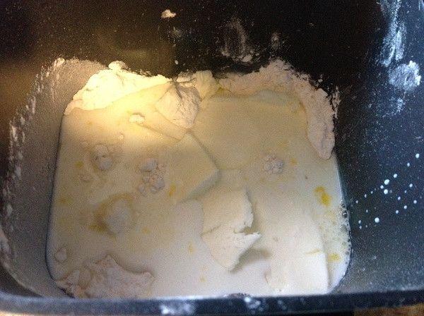 將所有麵包麵團材料稱重好,除了酵母粉外的所有材料都倒在一起.堆成中間高高的.倒成山的形狀,放入麵包機