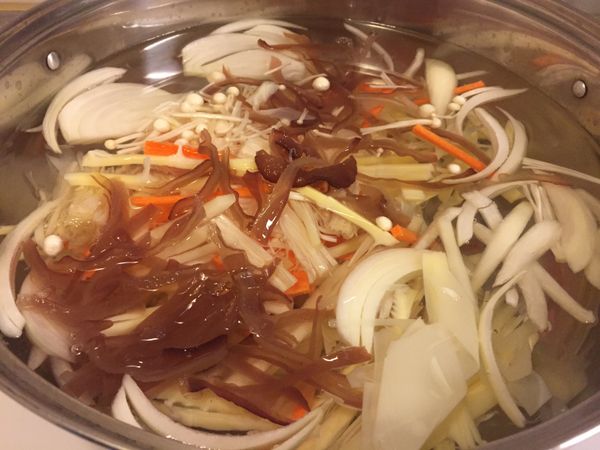起ㄧ鍋水加入紅蘿蔔絲、黑木耳絲、筍絲、洋蔥絲、香菇、金針菇等，ㄧ起熬煮湯頭較為清甜。大火煮滾後以小火熬煮15分鐘。